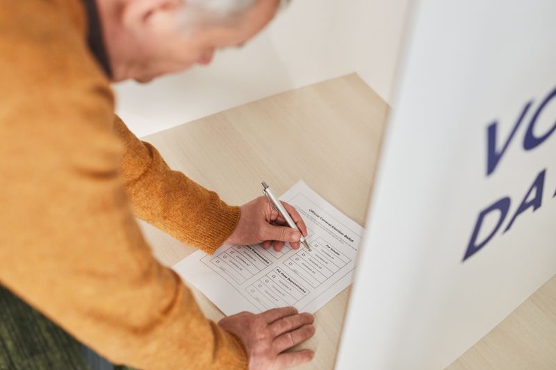 Person filling out a ballot at a voting booth